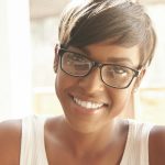 Nice close-up portrait of young girl in geeky glasses with pixie cut. Intelligent Spanish woman with
