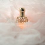 Perfume in gold bottle and pink soft background