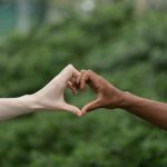 Two men are making heart with hands